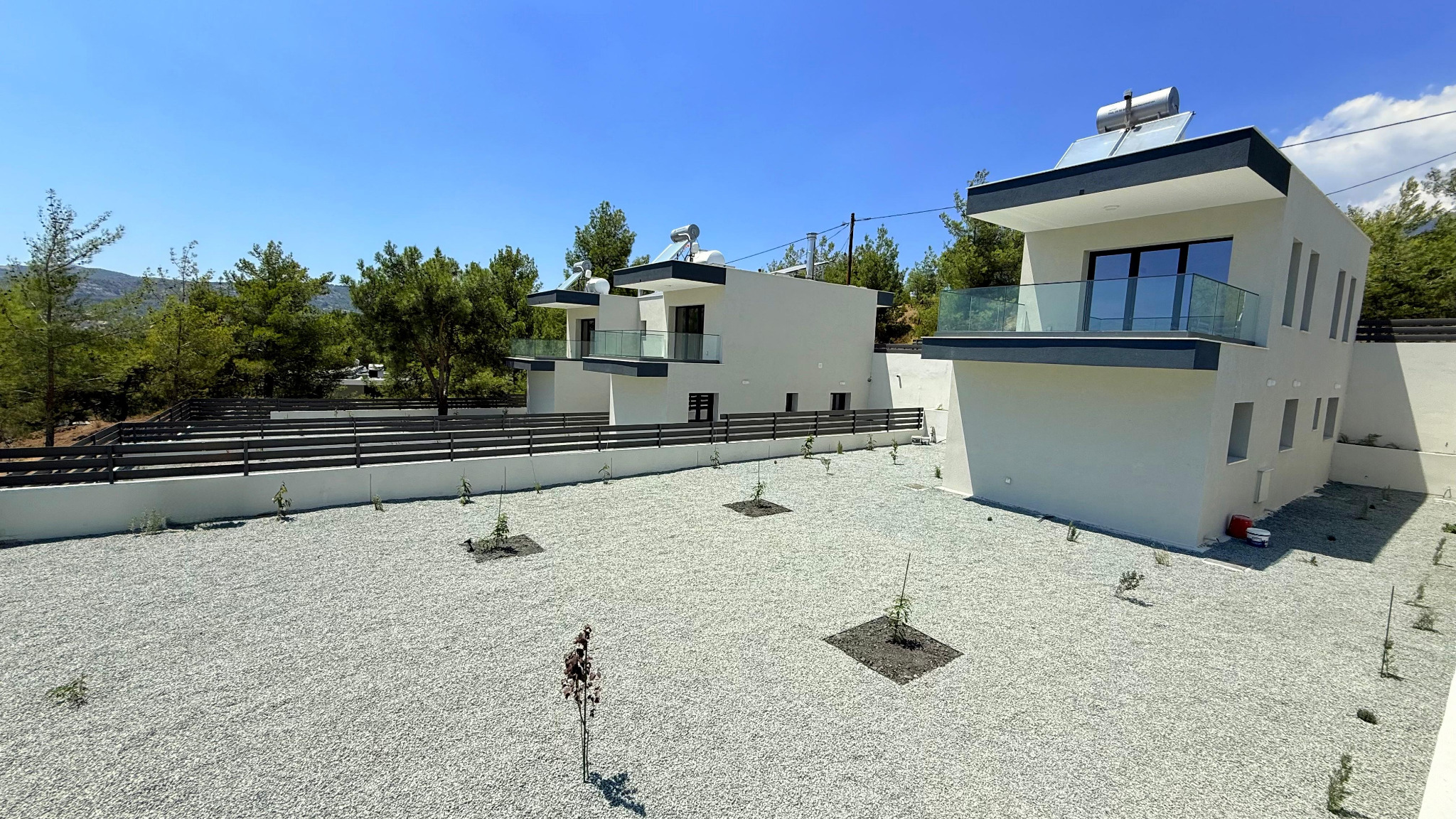 Completed Plot 1251 House 1 with its private garden and surrounding residences in Trimiklini